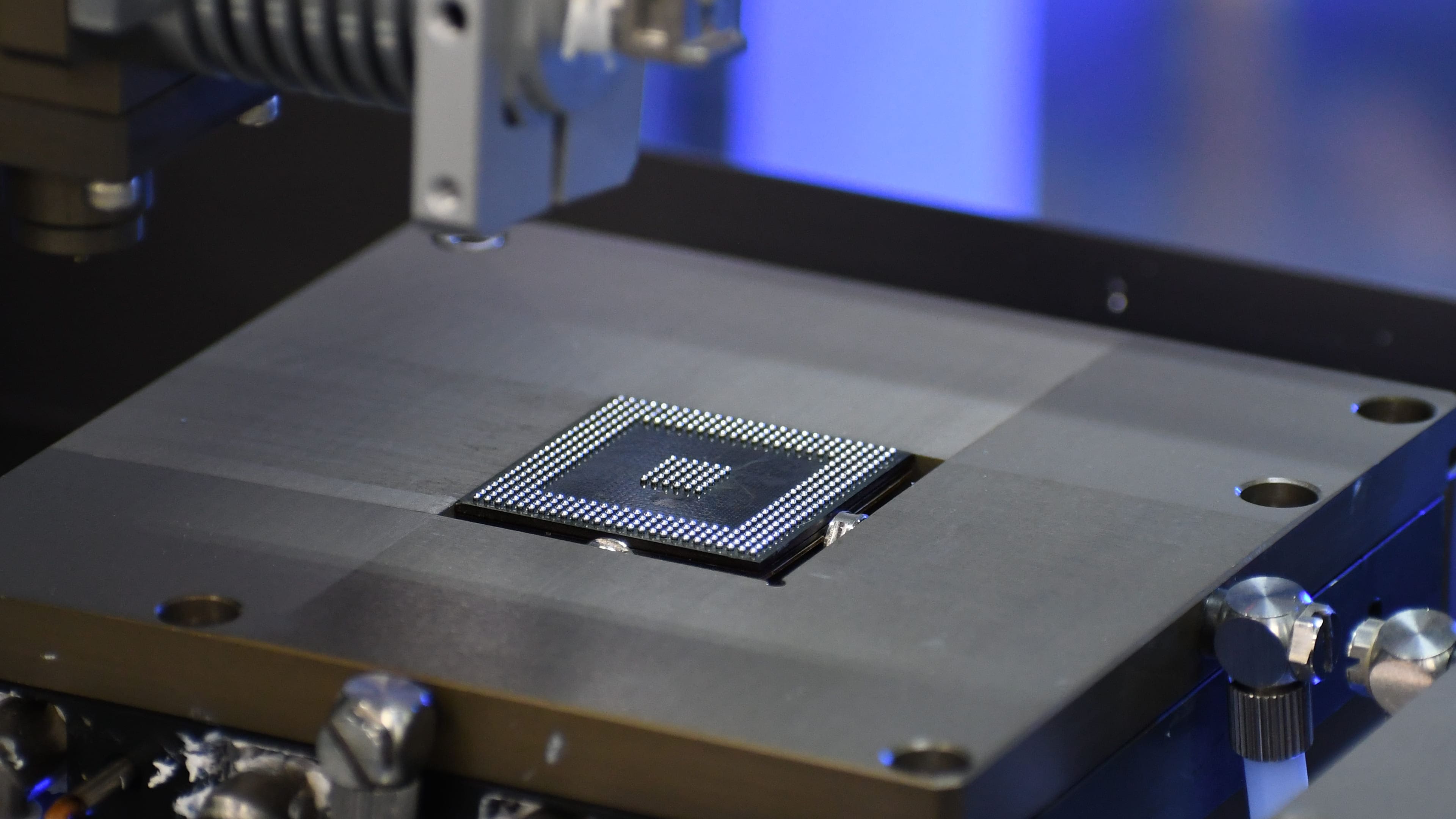 Industrial robot teach pendant displaying a 3D simulation of GETS’ automated semiconductor re-tinning machine and its position coordinates with a blue and white checkered background.